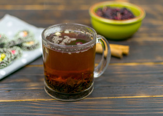 A cup with herbal tea and cookies on a dark background.