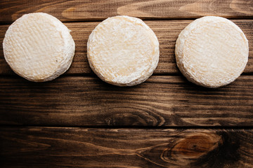 Top View of Crafted Cheese on Wooden Background with Free Space for Text at the Right Side of the Photo.
