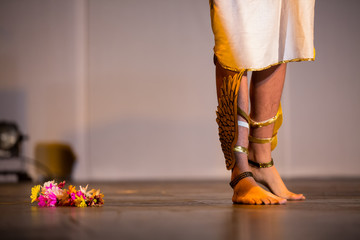 Actors legs in a theater performance with flowers on the floor. Actor playing hermes from greek...