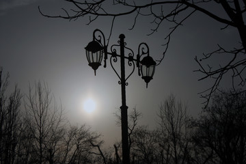 Lamppost gloomy photo on background with sun
