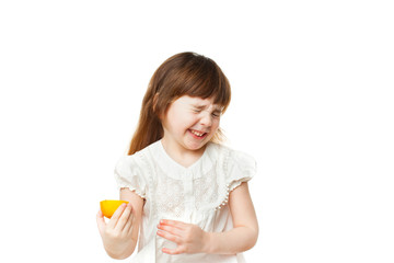 Girl 4-5 years crooked and eating lemon on white background