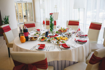 Wedding table setting in gorgeous banquet hall with burgundy
