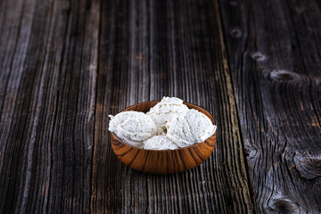 Vanilla ice cream with bowl on wooden background