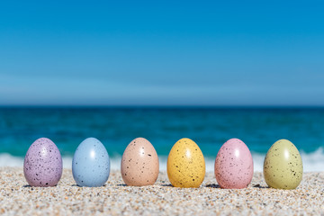 Colorful Easter eggs on the beach in sunny day. Easter concept.