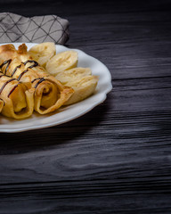 Pancakes with cottage cheese and a banana with chocolate syrup.