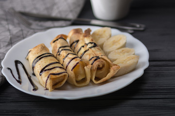 Pancakes with cottage cheese and a banana with chocolate syrup.