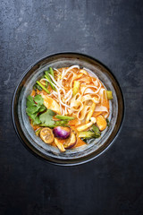 Traditional Thai kaeng phet red curry with vegetables and rice noodles as top view in a wok © HLPhoto