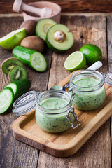 Healthy green yogurt sauce in glass jar with ingredients