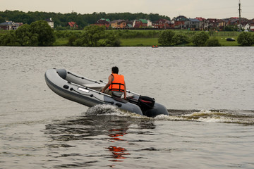 Man riding in an inflatable boat with a motor on sea