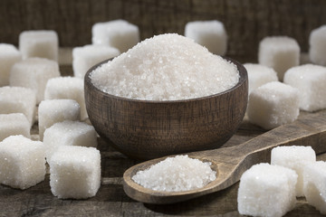White sugar in wooden bowl and spoon - cubes