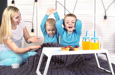 Mother wakes up her beloved sons. Breakfast in bed for children, surprise.	