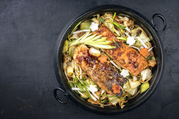 Japanese chan chan yaki hot pot with salmon fillet as top view in traditional cast iron pot