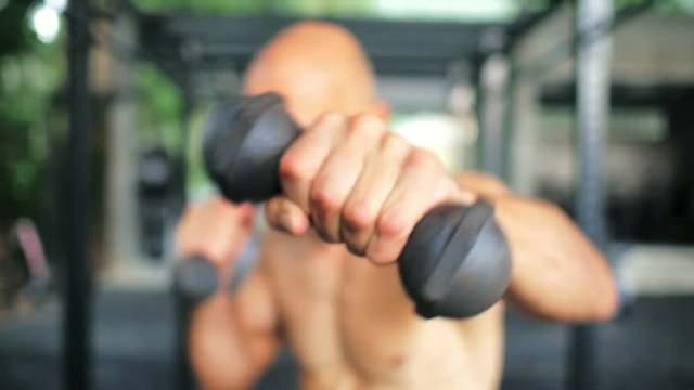 Man boxer training boxercise with dumbbells on fitness club close up