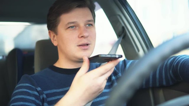 A Young Attractive Man Is Using A Mobile Phone On The Speakerphone In The Car