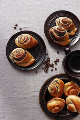 Buns of yeast dough with a poppy filling. Dark brown ceramic ware.