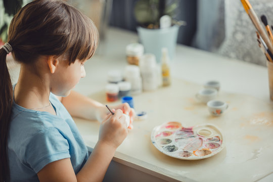 Girl painting on  the easter egg