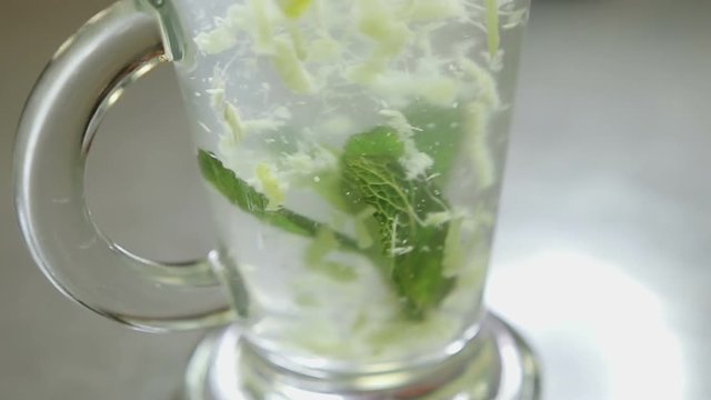 Mixing lemon, mint, ginger, water and sugar Close up