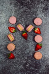 Pink macaroons on the dark background. Top view. Macarons isolated