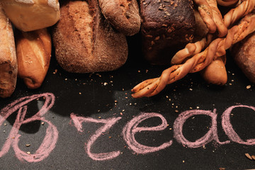 Fragrant bread on the table. Food on black background with text