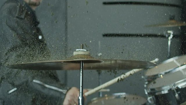  00:08 | 00:18 1×  Drummer hitting on drum cymbal, and the sand splashing from cymbal in slow motion 200 fps. Shot on RED HELIUM Cinema Camera.