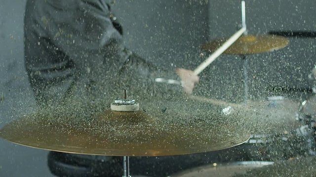  00:08 | 00:18 1&times;  Drummer hitting on drum cymbal, and the sand splashing from cymbal in slow motion 200 fps. Shot on RED HELIUM Cinema Camera.
