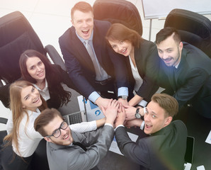 business team with hands clasped together on Desk