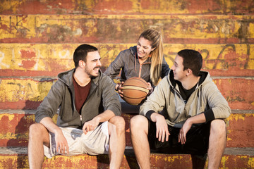 Three basketball players talking and laughing after  game