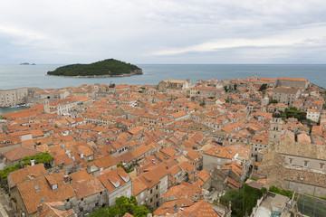 Fototapeta premium View over the orange rooftops of old town Dubrovnik from the ancient city wall with cloudy weather, Croatia