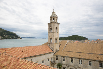 Fototapeta na wymiar Saint Dominic Church bell tower and red roofs of the Dominican Monastery in old town Dubrovnik, Croatia