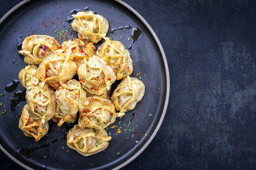 Traditional Kazakh manti steamed with mincemeat as top view on a plate with copy space right