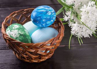 Easter eggs in a basket on a dark wooden background