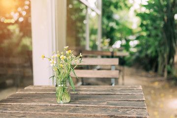 Flower in vase on a wooden table.