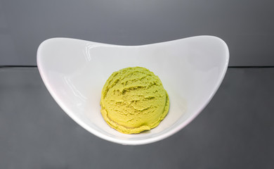 Green tea matcha ice cream scoop in white bowl