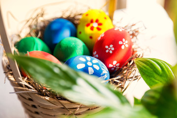 easter and holiday tradition concept - close up shoot of Colored Eggs in Basket