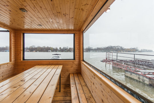 Sauna with sitting place and table, big bright window view on river