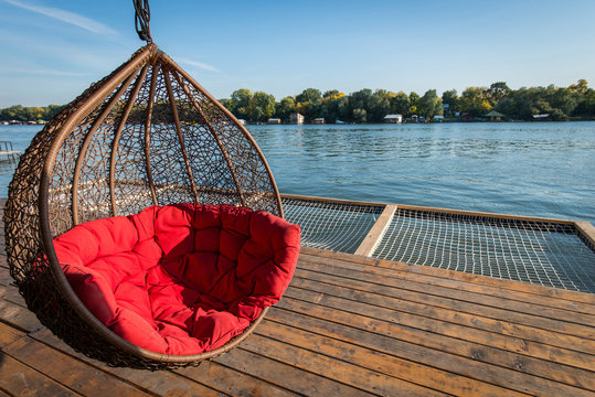 Hammock hanging chair with big red pillow and river scenic