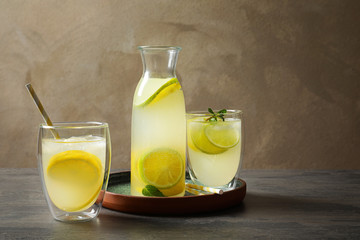 Jar with fresh lemonade and ingredients on table