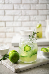 Jar with fresh lemonade and ingredients on table