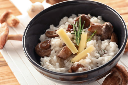 Bowl with risotto and mushrooms on table