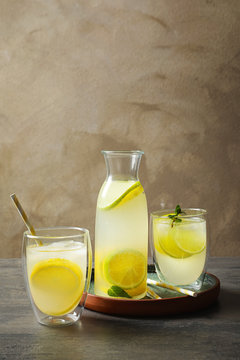 Jar with fresh lemonade and ingredients on table