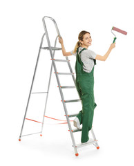 Young female decorator with paint roller on white background