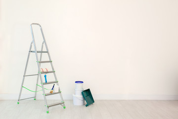 Set with decorator tools and paint on floor near color wall