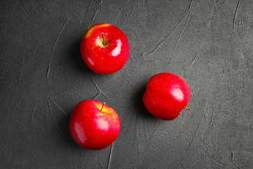 Ripe red apples on grey background