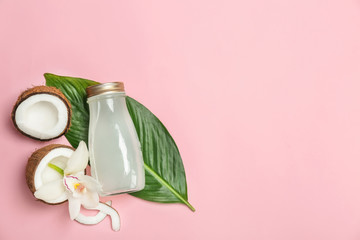 Bottle of coconut water and fresh nuts on color background