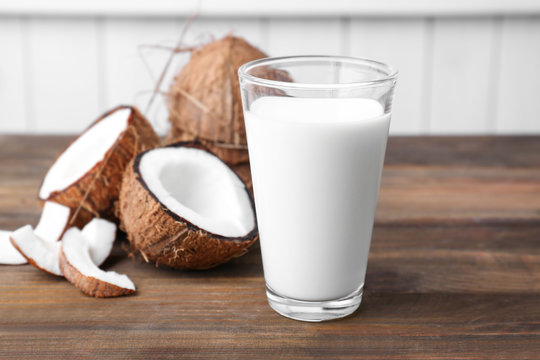 Glass of coconut milk on wooden table