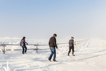 adult sisters walking in a snow covered meadow