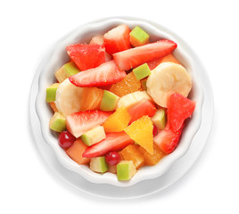 Bowl with fresh cut fruits on white background