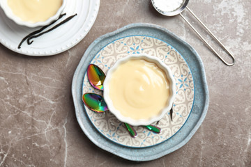 Bowl with vanilla pudding on light background