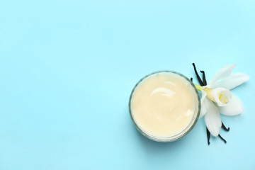 Vanilla pudding, sticks and flower on color background