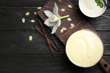 Vanilla pudding, sticks and flower on wooden background